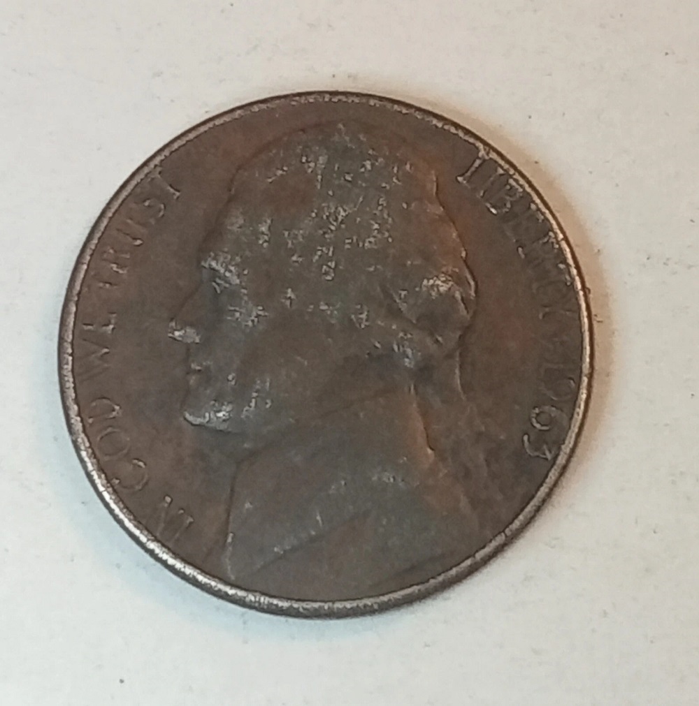 1963 Black Beauty nickel with unusually dark near-black surfaces compared to a standard silver-gray 1963 Jefferson Nickel